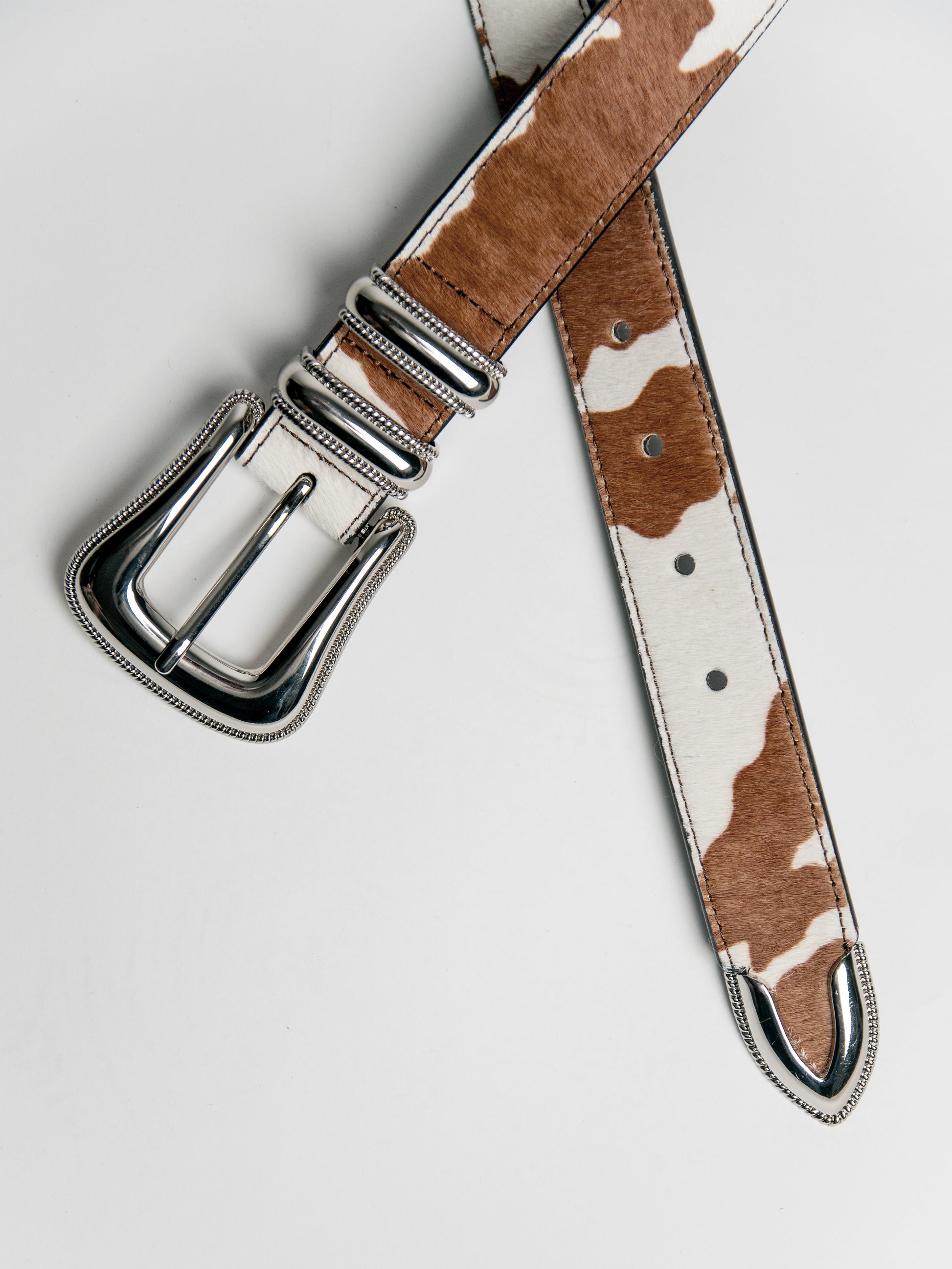 Flat lay - close up front - Genuine leather - big buckle - silver hardware - cowhide texture - horsehair texture 